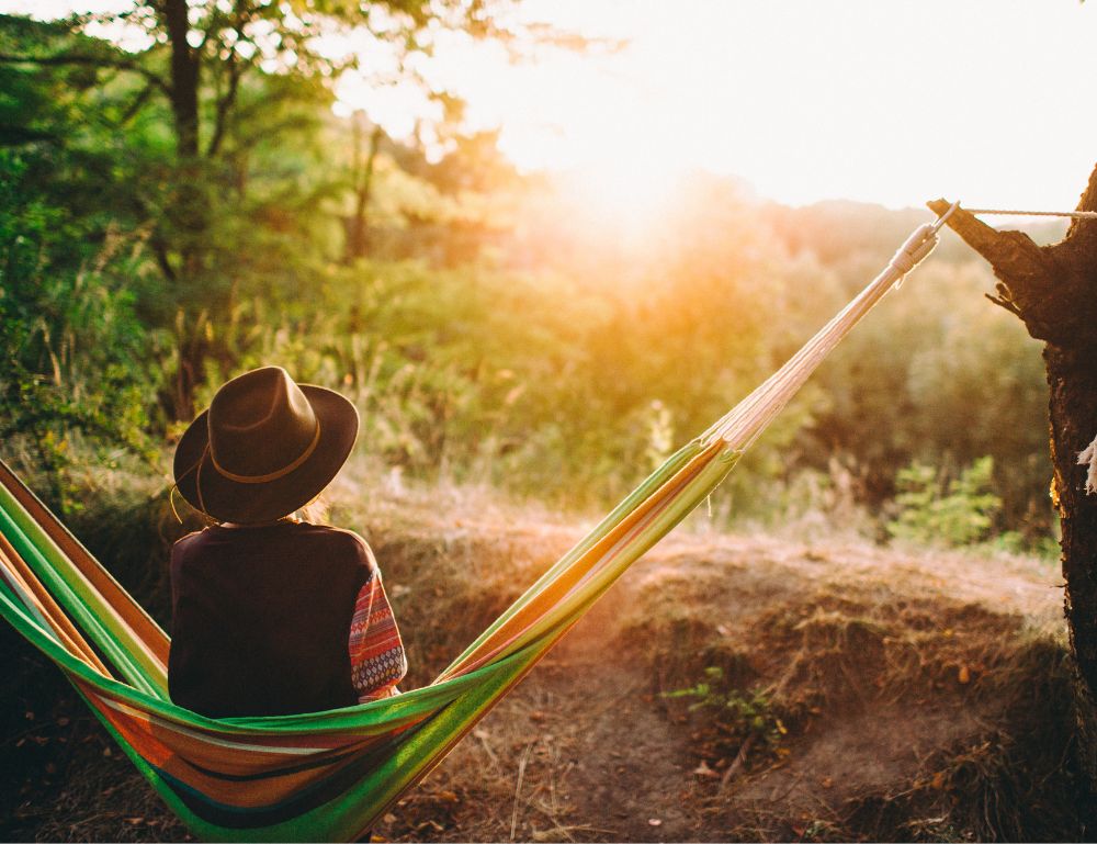 Woman on a hammock looking out over a forest