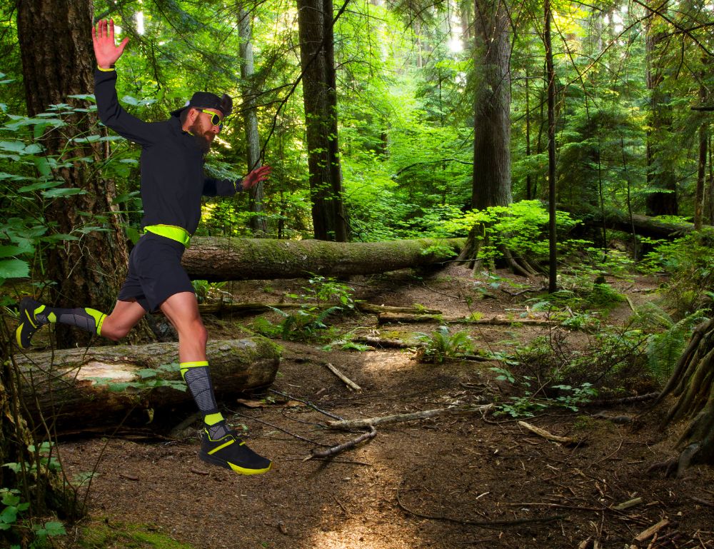 Man trailing running through a green forest